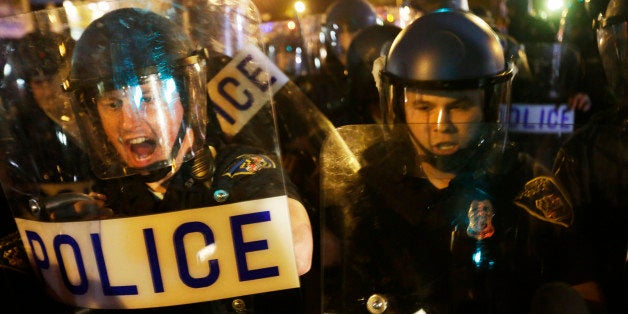 Police in riot gear push back on media and a crowd gathering in the street after a 10 p.m. curfew went into effect Thursday, April 30, 2015, in Baltimore. The curfew was imposed after unrest in the city over the death of Freddie Gray while in police custody. (AP Photo/David Goldman)