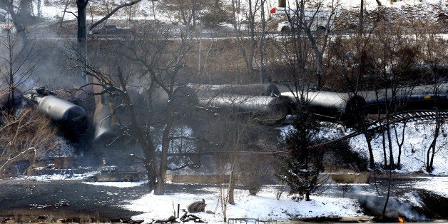 FILE-This Feb. 17, 2015 file photo, shows a train derailment that sent a tanker with crude oil into the Kanawha River near Mount Carbon, W.Va. As investigators in West Virginia and Ontario pick through the wreckage from the latest pair of oil train derailments to result in massive fires, U.S. transportation officials predict many more catastrophic wrecks involving flammable fuels in coming years absent new regulations. (AP Photo/Chris Tilley,File)