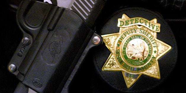 Siskiyou County Sheriff Detective Darrel Lemos, 33, wears his badge, shown Wednesday, Feb. 26, 3003, in Yreka, Calif., on his