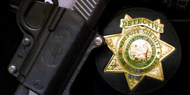 Siskiyou County Sheriff Detective Darrel Lemos, 33, wears his badge, shown Wednesday, Feb. 26, 3003, in Yreka, Calif., on his belt during the day as a detective and on his shirt at night while on patrol. By day, twice a week, Lemos works as a plain-clothed detective assigned to marijuana eradication, sex crimes and homicides. By night, he suits up in his old uniform and fills in on patrol shifts. (AP Photo/Michael Burke)