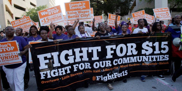 Protestors march in support of raising the minimum wage to $15 an hour as part of an expanding national movement known as Fight for 15, Wednesday, April 15, 2015, in Miami. The event was part of a national protest day to coincide with the April 15 deadline for filing income taxes. (AP Photo/Lynne Sladky)