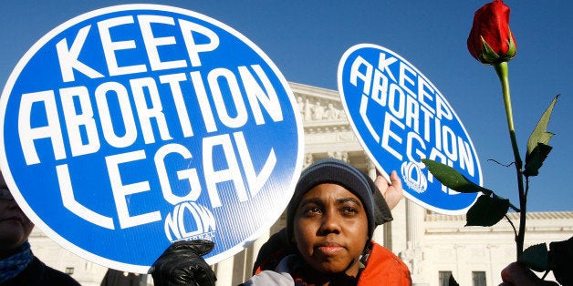 WASHINGTON - JANUARY 22: Local pro-choice activist Lisa King holds a sign in front of the U.S. Supreme Court as a pro-life activist holds a rose nearby during the annual 'March for Life' event January 22, 2009 in Washington, DC. The event was to mark the anniversary of the 1973 Roe v Wade Supreme Court abortion ruling. (Photo by Alex Wong/Getty Images)