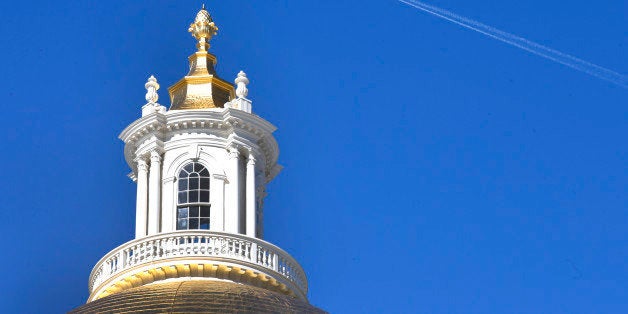 An airplane leaves a trail as it flies the blue sky above the Statehouse in Boston, Thursday, Feb. 20, 2014. (AP Photo/Elise Amendola)