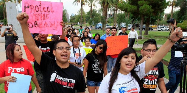 FILE - In this Aug. 16, 2012 file photo, Joshua Montano, left, and Deborah Robles protest in front of the Capitol the day after Arizona Gov. Jan Brewer, in an executive order reaffirming Arizona state law denying young illegal immigrants driver's licenses and other public benefits in Phoenix. Organizations that advocate for immigrant rights on Thursday, Nov. 29, 2012 filed a lawsuit seeking to reverse an order by Jan Brewer that denies driving licenses to young immigrants who have obtained work permits and avoided deportation thanks to a new policy of President Barack Obama. The lawsuit alleges that Arizona's order actually classifies called "dreamers" as immigrants without permission to reside in the United States. The organizations asked a federal judge to declare unconstitutional the order because federal law takes precedence and because it denies licenses without a valid excuse. (AP Photo/Ross D. Franklin, File)