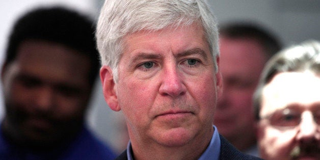 DETROIT, MI - JANUARY 14: Michigan Gov. Rick Snyder visits the Denso display to talk about Michigan and automatic vehicle tec