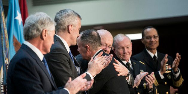US Secretary of Defense Chuck Hagel, from left, White House Chief of Staff Denis McDonough, Chairman of the Join Chief of Staff Army Gen. Martin Dempsey and Adm. Cecil Haney, commander of U.S. Strategic Command, applaud while Gen.Keith B. Alexander embraces Director of National Intelligence James R. Clapper during Alexander's retirement ceremony at the National Security Agency Friday, March 28, 2014, at Fort Meade, Md. (AP Photo/Brendan Smialowski, Pool)