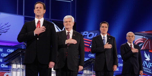 JACKSONVILLE, FL - JANUARY 26: Republican presidential candidates (L-R) former U.S. Sen. Rick Santorum, former Speaker of the House Newt Gingrich (R-GA), former Massachusetts Gov. Mitt Romney and U.S. Rep. Ron Paul (R-TX) place their hands over their hearts during the National Anthem at the start of a debate sponsored by CNN, the Republican Party of Florida and the Hispanic Leadership Network at the University North Florida on January 26, 2012 in Jacksonville, Florida. The debate is the last one before the Florida primaries January 31st. (Photo by Chip Somodevilla/Getty Images)