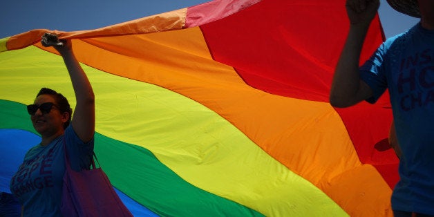 WEST HOLLYWOOD, CA - JUNE 8: Marchers carry a rainbow flag in the LA Pride Parade on June 8, 2014 in West Hollywood, California. The LA Pride Parade and weekend events this year are emphasizing transgender rights and issues. The annual LGBT pride parade begin in 1970, a year after the Stonewall riots, and historically attracts more than 400,000 spectators and participants. (Photo by David McNew/Getty Images)