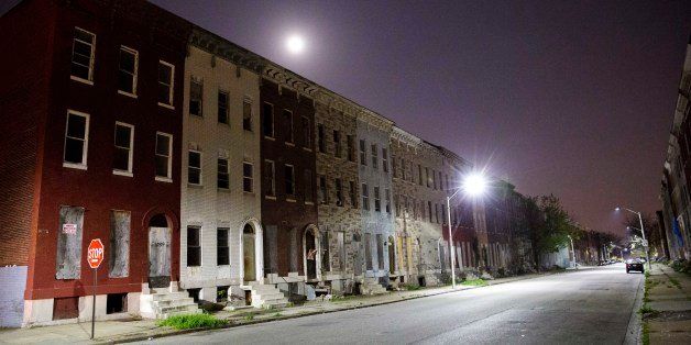 The moon rises above a block of blighted row houses in the neighborhood where Freddie Gray was arrested as a six day curfew was lifted Sunday, May 3, 2015, in Baltimore. (AP Photo/David Goldman)