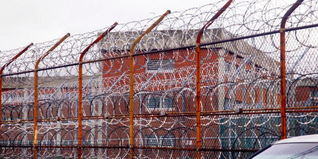 FILE - In this March 16, 2011, file photo, a security fence surrounds the inmate housing on New York's Rikers Island correctional facility in New York. A wide-ranging independent review, obtained by The Associated Press, is critical of the city's use of solitary confinement at Rikers Island, as punishment for inmates who by the very nature of their mental illnesses are more prone to breaking jailhouse rules. The report recommends eliminating the use of solitary for mentally ill inmates as a punishment and instead partnering with a teaching hospital to provide intensive therapeutic services. The study was commissioned by the New York City Board of Correction, which has a watchdog role over the city's Department of Correction. (AP Photo/Bebeto Matthews, File)