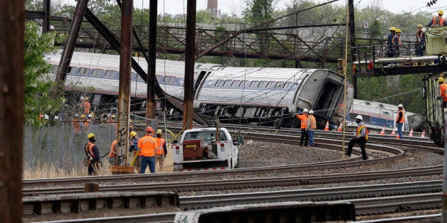 Emergency personnel gather near the scene of a deadly train wreck, Wednesday, May 13, 2015, after a fatal Amtrak derailment Tuesday night, in the Port Richmond section of Philadelphia. Federal investigators arrived Wednesday to determine why an Amtrak train jumped the tracks in a wreck that killed at least six people, and injured dozens. (AP Photo/Mel Evans)