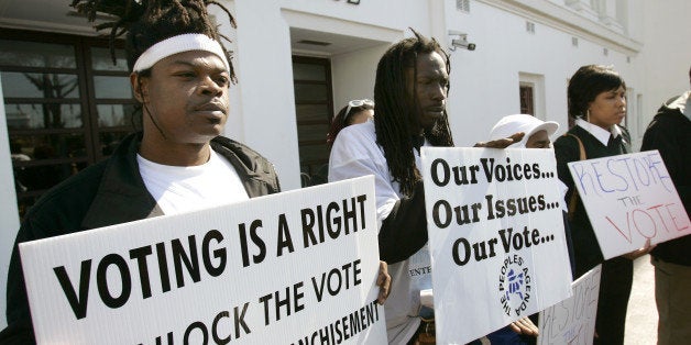 Supporters for a bill that would automatically restore voting rights to convicted felons upon their release from prison hold up signs supporting the bill during a news conference Thursday, Feb. 9, 2006, in front of the State House in Montgomery, Ala. Sen. Bobby Singleton, D-Greensboro, who is sponsoring the bill, said the current system has created long delays in restoring voting rights to inmates who have already "paid their debt to society." (AP Photo/Rob Carr)