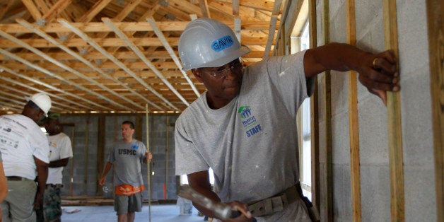 Gavin Canady, of Habitat for Humanity, right, works with former U.S. Marine Dan Caporale, of Fort Lauderdale, Fla., center, in building a Habitat for Humanity home as part of The Mission Continues project, Tuesday, Nov. 8, 2011, in Miami. The Mission Continues is a nonprofit organization that encourages returning veterans to do community service work, through paid fellowships and as volunteers. Caporale served with the Marines for eight years until 2000. (AP Photo/Lynne Sladky)