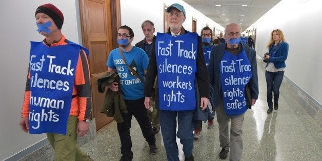 Demonstrators gather in the Dirksen Senate Office Building before a silent protest against 'Flood Congress: Opponets of Fast Track Trade Authority on March 19, 2015 in Washington, DC. AFP PHOTO/MANDEL NGAN (Photo credit should read MANDEL NGAN/AFP/Getty Images)