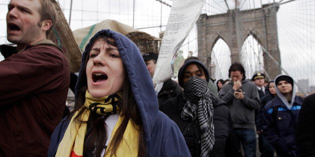 Occupy Wall Street activists march over the Brooklyn Bridge, Sunday, April 1, 2012 in New York. The protestors marched across the Brooklyn Bridge to mark six months since hundreds of them were arrested on the bridge. (AP Photo/Mary Altaffer)