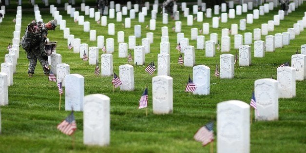 A soldier from the 3rd US Infantry Regiment, 'The Old Guard,' places flags at grave sites during the 'Flags-In' ceremony at Arlington National Cemetery in Arlington, Virginia, on May 22, 2014. A US American flag was placed one foot in front of more than 220,000 graves in the cemetery to mark the Memorial Day. AFP PHOTO/Jewel Samad (Photo credit should read JEWEL SAMAD/AFP/Getty Images)