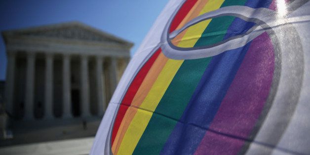 WASHINGTON, DC - JANUARY 09: An activist flies a 'marriage pride flag' outside the U.S. Supreme Court January 9, 2015 in Washington, DC. The justices of the Supreme Court were scheduled to meet to determine whether the court will take up any of the five pending state-banned same-sex marriage cases in Ohio, Tennessee, Michigan, Kentucky and Louisiana. (Photo by Alex Wong/Getty Images)