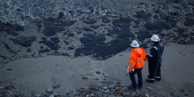 GOLETA, CALIFORNIA - MAY 19: Officials walk along an the oil-covered beach on May 19, 2015 north of Goleta, California. About 21,000 gallons spilled from an abandoned pipeline on the land near Refugio State Beach, spreading over about four miles of beach within hours. The largest oil spill ever in U.S. waters at the time occurred in the same section of the coast in 1969 where numerous offshore oil platforms can be seen, giving birth to the modern American environmental movement. (Photo by David McNew/Getty Images)