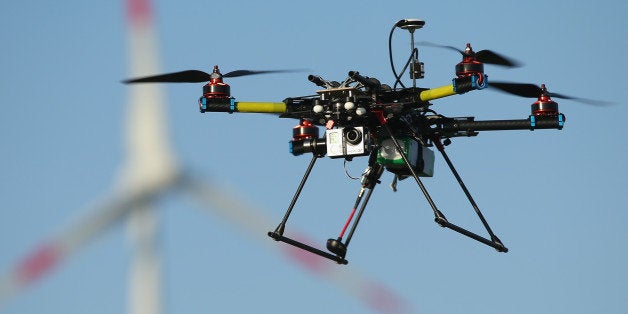 ZEESTOW, GERMANY - MAY 15: A multirotor quadcopter drone used for aerial photography flies near a wind turbine on June 7, 20