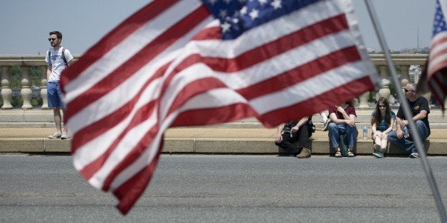 People watch motorcyclists during Rolling Thunder on May 24, 2015 in Washington, DC, as the US marks Memorial Day, May 25. The Rolling Thunder First Amendment Demonstration Run is an annual event to pay tribute to current and former US military members. AFP PHOTO/BRENDAN SMIALOWSKI (Photo credit should read BRENDAN SMIALOWSKI/AFP/Getty Images)