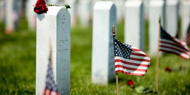 A rose lays on top of a headstone in Section 60 of Arlington National Cemetery in Arlington, Va., where many of the soldiers who died in Iraq and Afghanistan are buried, on Memorial Day, Monday, May 25, 2015. (AP Photo/Andrew Harnik)