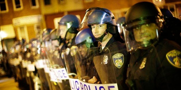 Police line up in riot gear after a 10 p.m. curfew went into effect Thursday, April 30, 2015, in Baltimore. The curfew was imposed after unrest in the city over the death of Freddie Gray while in police custody. (AP Photo/David Goldman)