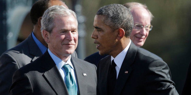 President Barack Obama shakes hands with Former President George W. Bush after Obama spoke to a large crowd near the Edmund P