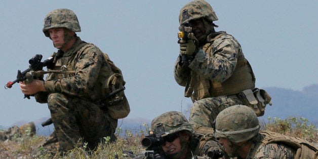 U.S. troops take their positions during a combined assault exercise at a beach facing one of the contested islands off the South China Sea known as Scarborough Shoal in the West Philippine Sea Tuesday, April 21, 2015 at the Naval Education and Training Command at San Antonio township, Zambales province, northwest of Manila, Philippines. More than ten thousand troops from both the US and Philippine militaries are taking part in the annual military drill that focuses on regional security, terrorism, disaster preparedness and inter-operability of both countries. (AP Photo/Bullit Marquez)