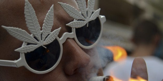 A man smokes marijuana during a demo for its legalization, in Medellin, Antioquia department, Colombia on May 2, 2015. The de