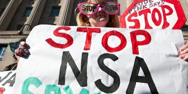 Civil liberties activists hold a rally against surveillance of US citizens as US President Barack Obama is expected to announce reforms of the National Security Agency (NSA) at the Justice Department in Washington on January 17, 2014. Obama will announce plans to stop the NSA from hoarding hundreds of millions of telephone call records. The US surveillance programs was exposed by Edward Snowden. AFP PHOTO/Nicholas KAMM (Photo credit should read NICHOLAS KAMM/AFP/Getty Images)