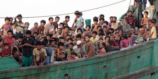 Migrants sit on their boat as they wait to be rescued by Acehnese fishermen on the sea off East Aceh, Indonesia, Wednesday, May 20, 2015. Hundreds of migrants stranded at sea for months were rescued and taken to Indonesia, officials said Wednesday, the latest in a stream of Rohingya and Bangladeshi migrants to reach shore in a growing crisis confronting Southeast Asia. (AP Photo/S. Yulinnas)