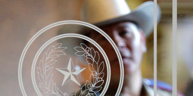 A Texas state trooper stands outside of a hearing where lawmakers discuss whether to legalize concealed handguns on college campuses and open carry everywhere else, Thursday, Feb. 12, 2015, in Austin, Texas. (AP Photo/Eric Gay)