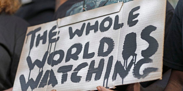 A man holds a sign during a protest for the shooting death of Walter Scott at city hall in North Charleston, S.C., Wednesday, April 8, 2015. Scott was killed by a North Charleston police officer after a traffic stop on Saturday. The officer, Michael Thomas Slager, has been charged with murder. (AP Photo/Chuck Burton)