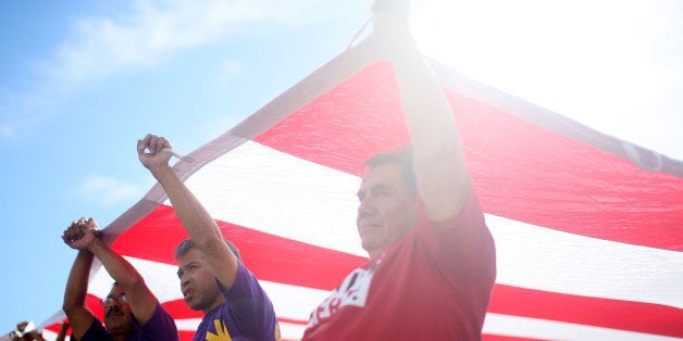 LOS ANGELES, CA - MAY 1: Protesters chant while carrying an American flag during a May Day rally on Friday, May 1, 2015 in downtown Los Angeles, California. Many of the protesters were calling on leaders in Washington to come up with a comprehensive immigration plan, higher wages for for minimum wage earners and to protest police brutality and show solidarity with protesters in Baltimore.(Photo by Sandy Huffaker/Getty Images)