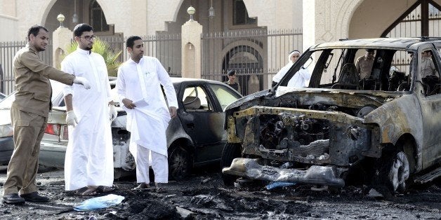 Saudi security forces and forensic personnel inspect the site of a suicide bombing that targeted the Shiite Al-Anoud mosque i