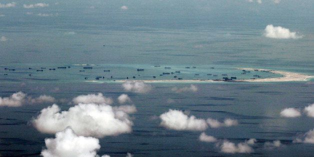This areal photo taken through a glass window of a military plane shows China's alleged on-going reclamation of Mischief Reef in the Spratly Islands in the South China Sea Monday, May 11, 2015. Gen. Gregorio Pio Catapang, the Philippines' military chief, has flown to Pag-asa Island, a Filipino-occupied island in the South China Sea amid territorial disputes in the area with China, vowing to defend the islet and help the mayor develop tourism and marine resources there. (Ritchie B. Tongo/Pool Photo via AP)