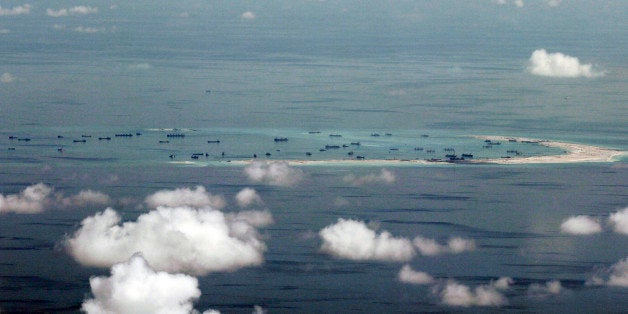 This areal photo taken through a glass window of a military plane shows China's alleged on-going reclamation of Mischief Reef