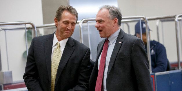 Sen. Jeff Flake, R-Ariz., left, is greeted by Sen. Tim Kaine, D-Va., as they make their way to a vote at the Capitol in Washington, Monday, Feb. 9, 2015. (AP Photo/J. Scott Applewhite)
