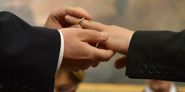A same-sex couple exchanges rings after they registered their civil union at Rome's city hall on May 21, 2015 in Rome. The ci
