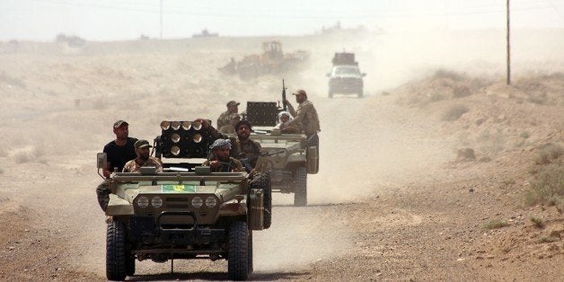 Iraqi security forces and paramilitaries deploy, on May 26, 2015, in al-Nibaie area, north-west of Baghdad, during an operation aimed at cutting off Islamic State (IS) jihadists in Anbar province before a major offensive to retake the city of Ramadi. Iraqi forces closed in on Ramadi and launched the operation dubbed Labaik ya Hussein', which roughly translates as 'We are at your service, Hussein' and refers to one of the most revered imams in Shiite Islam. It will see a mix of security forces and paramilitaries move south towards the city from Salaheddin province, said Hashed al-Shaabi ('popular mobilisation' in Arabic) spokesman Ahmed al-Assadi. AFP PHOTO/AHMAD AL-RUBAYE (Photo credit should read AHMAD AL-RUBAYE/AFP/Getty Images)