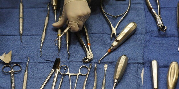A volunteers gets dental tools for dentists giving free dental care at a clinic at the Los Angeles Sports Arena sponsored by