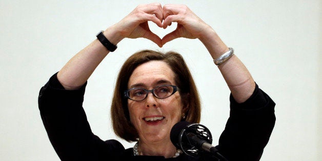 Oregon Gov. Kate Brown forms a heart with her hands as she says "I love Oregon" during her State of the State address in Portland, Ore., Friday, April 17, 2015. (AP Photo/Don Ryan)