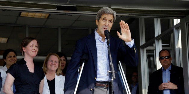 Secretary of State John Kerry waves after speaking to media as he is discharged from Massachusetts General Hospital Friday, June 12, 2015, in Boston. Kerry was released from the hospital after undergoing surgery on a broken leg sustained in a May 31 bicycle accident in France. (AP Photo/Elise Amendola)