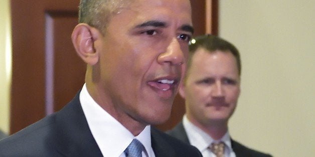 US President Barack Obama walks through a hallway after meeting with House Democrats at the US Capitol on June 12, 2015 in Wa