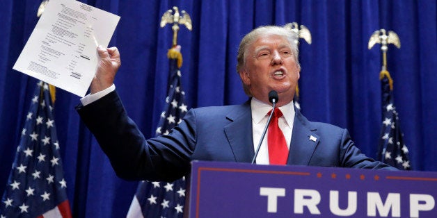 Developer Donald Trump displays a copy of his net worth during his announcement that he will seek the Republican nomination for president, Tuesday, June 16, 2015, in the lobby of Trump Tower in New York. (AP Photo/Richard Drew)