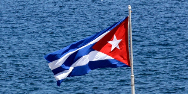 A spectator watches American Hobie Cat sailboat racers and Cuba's Olympic team sailors, take part in a regatta right off the