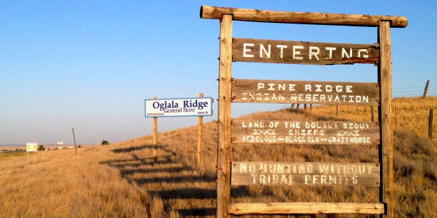 FILE - This Sept. 9, 2012 file photo shows the entrance to the Pine Ridge Indian Reservation in South Dakota, home to the Oglala Sioux tribe. Tribal official Isaac Last Horse says there is a shortage of police officers on the reservation. Last Horse says a full contingent of officers would be 51 but the police department has just 36. He says many officers have taken jobs in North Dakota, where higher wages are paid. (AP Photo/Kristi Eaton, File)