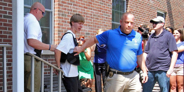 Charleston, S.C., shooting suspect Dylann Storm Roof, second from left, is escorted from the Shelby Police Department in Shelby, N.C., Thursday, June 18, 2015. Roof is a suspect in the shooting of several people Wednesday night at the historic The Emanuel African Methodist Episcopal Church in Charleston, S.C. (AP Photo/Chuck Burton)