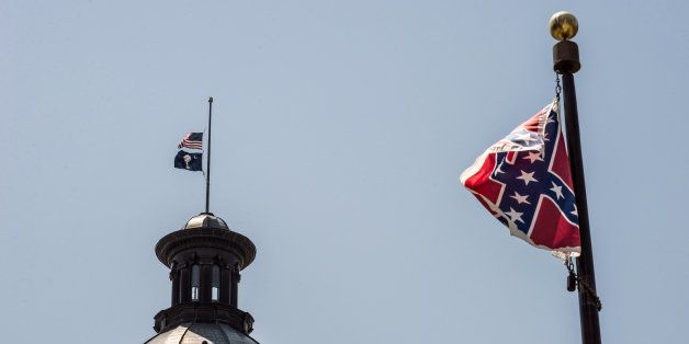 COLUMBIA, SC - JUNE 18: The South Carolina and American flags fly at half mast as the Confederate flag unfurls below at the Confederate Monument June 18, 2015 in Columbia, South Carolina. Legislators gathered Thursday morning to honor their co-worker Clementa Pinckney and the eight others killed yesterday at Emanuel AME Church in Charleston, South Carolina. (Photo by Sean Rayford/Getty Images)