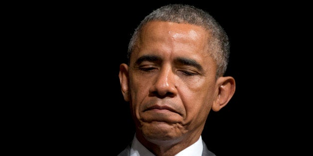 President Barack Obama pauses as he sits on stage as Attorney General Loretta Lynch speaks during her investiture ceremony, Wednesday, June 17, 2015, at the Warner Theatre in Washington. (AP Photo/Carolyn Kaster)